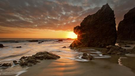 Serene Sunset Over Rocky Shoreline wallpaper