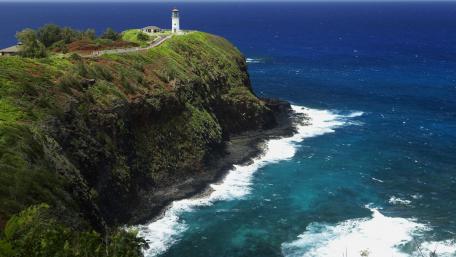 Majestic Lighthouse Overlooking Vibrant Ocean Waves wallpaper