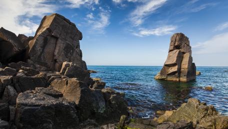 Majestic Rocky Coastline Under Blue Skies wallpaper