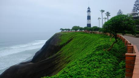 Lighthouse by the Shore in Tranquil Foggy Setting wallpaper
