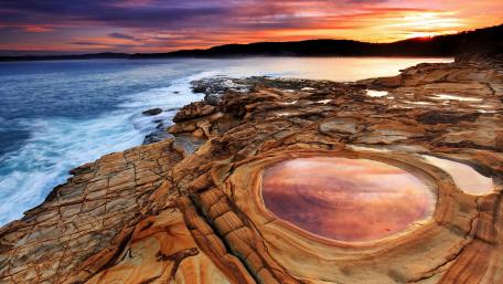 Serene Coastal Sunset Over Rocky Shoreline wallpaper