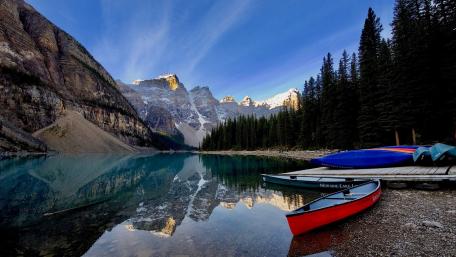 Serene Mountain Lake with Reflection and Canoes wallpaper