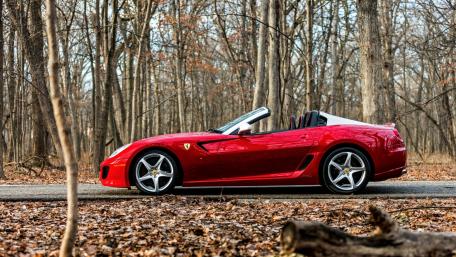 Sleek Red Convertible Amidst Autumn Woods wallpaper