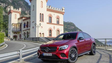 Sleek Red Luxury SUV on Scenic Roadway wallpaper