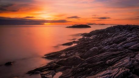 Serene Sunset Over Rocky Coastline wallpaper