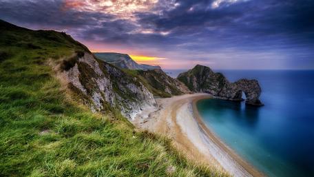 Serene Coastal Sunset Overlooking Dramatic Cliffs wallpaper