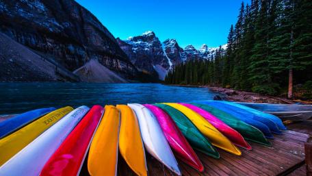 Vibrant Canoes by Serene Mountain Lake wallpaper