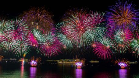Vibrant Fireworks Display Over Calm Waters wallpaper