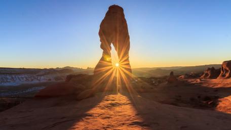 Majestic Sunrise Through Rock Archway wallpaper