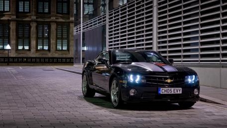 Sleek Black Camaro in Urban Nightscape wallpaper