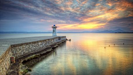Serene Coastal Sunset with Lighthouse View wallpaper