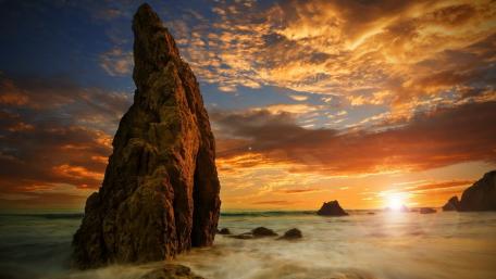 Majestic Sunset Over the Rocky Shoreline wallpaper