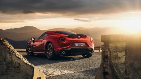Sleek Alfa Romeo in Vibrant Sunset Setting wallpaper