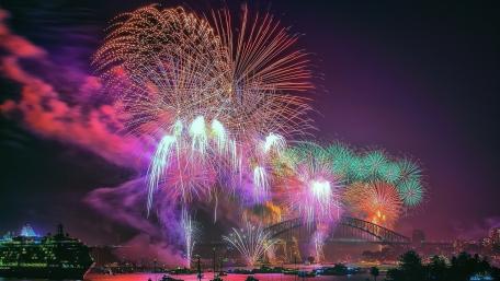 Vibrant Fireworks Over Cityscape Night Sky wallpaper