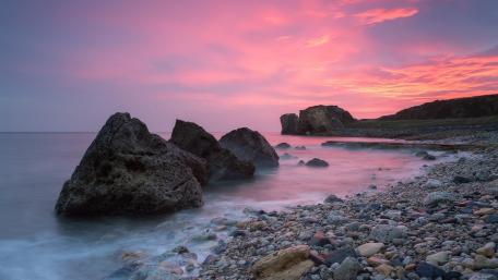 Tranquil Shoreline Under a Colorful Sky wallpaper