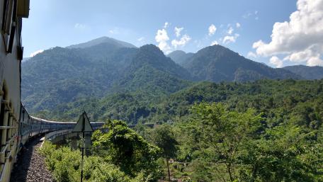 Scenic Train Journey Through Lush Mountains wallpaper