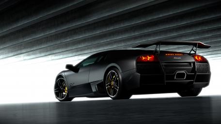 Sleek Black Lamborghini in Shadowed Garage wallpaper