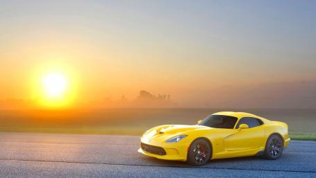 Stylish Yellow Car Under a Breathtaking Sunrise wallpaper