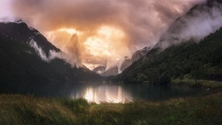 Serene Mountain Lake Under Dramatic Clouds wallpaper