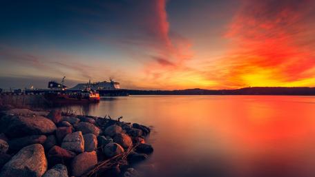 Stunning Sunset Over Tranquil Waters and Rocks wallpaper