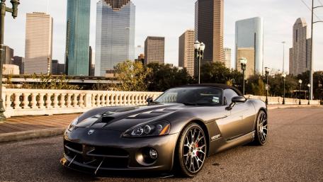 Sleek Silver Sports Car Against Urban Skyline Scene wallpaper