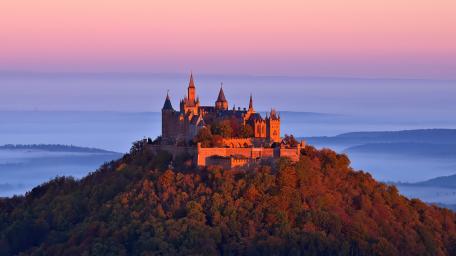 Majestic Castle at Sunset Overlooking Serene Landscape wallpaper