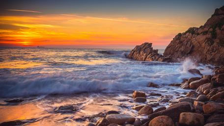 Majestic Sunset Over Cliffside Waves wallpaper