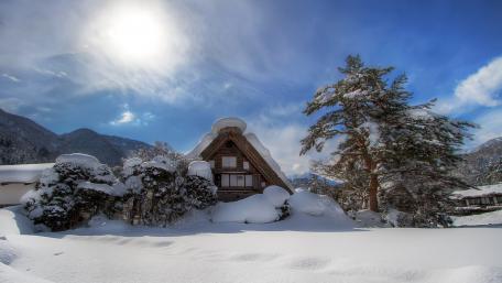 Winter Cottage Serenity Amongst Snowy Peaks wallpaper