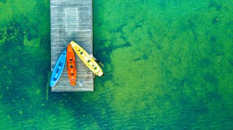 Vibrant Kayaks on Tranquil Lake Pier View wallpaper