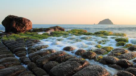 Tranquil Shoreline with Boulders and Algae wallpaper
