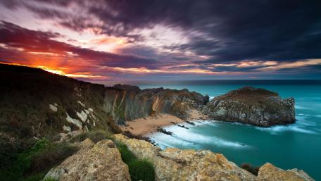 Serene Sunset Over Cloudy Shoreline wallpaper