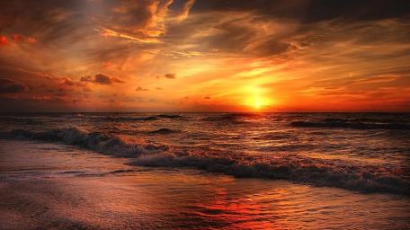 Fiery Sunset Over the Ocean Waves wallpaper