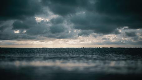 Dark Clouds Over a Serene Lake Scene wallpaper