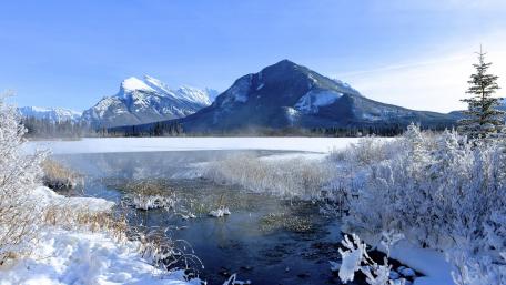 Majestic Winter Landscape Featuring Frozen Lake and Mountains wallpaper