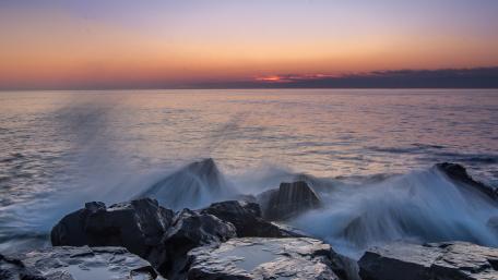Serene Sunset Over Rocky Shoreline wallpaper