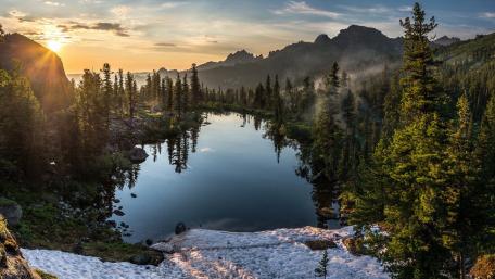 Serene Mountain Lake at Sunrise with Mist and Reflection wallpaper