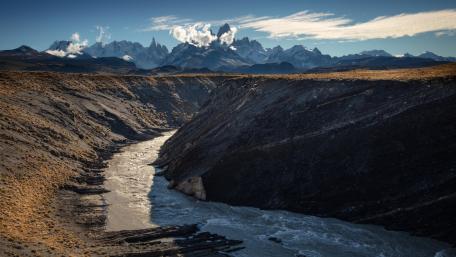 Majestic River Carving Through Rugged Terrain wallpaper