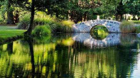 Serene Stone Bridge Over Tranquil Pond wallpaper