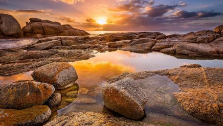 Serene Sunset Over Rocky Beach Reflection wallpaper