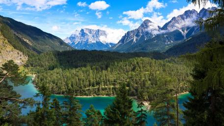Breathtaking River Valley Amidst Majestic Mountains wallpaper