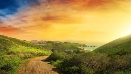 Serene Sunset Over Coastal Landscape Patterned Roadway wallpaper