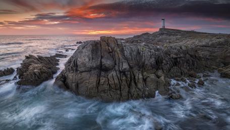 Majestic Lighthouse by the Sea at Sunset wallpaper