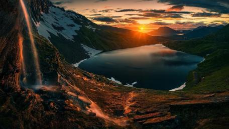 Serene Sunset Over Tranquil Lake and Waterfall wallpaper