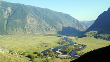 Serene River Flowing Through Majestic Valley Landscape wallpaper