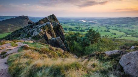 Majestic Rock Formation Overlooking Lush Landscape wallpaper