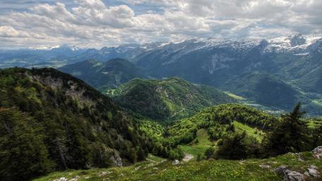 Majestic Green Alps Under Cloudy Skies wallpaper