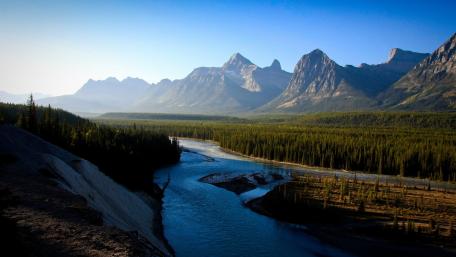 Serene River Flowing Through Majestic Mountains wallpaper