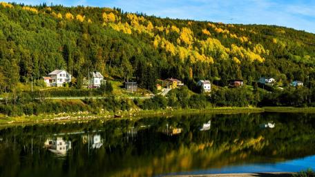 Serene Village Reflected in Calm River Waters wallpaper