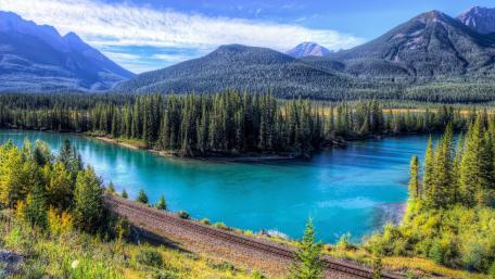 Tranquil River Flowing Through Majestic Mountains wallpaper