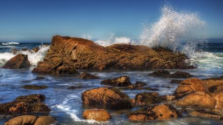 Majestic Waves Crashing on Rocky Shoreline wallpaper